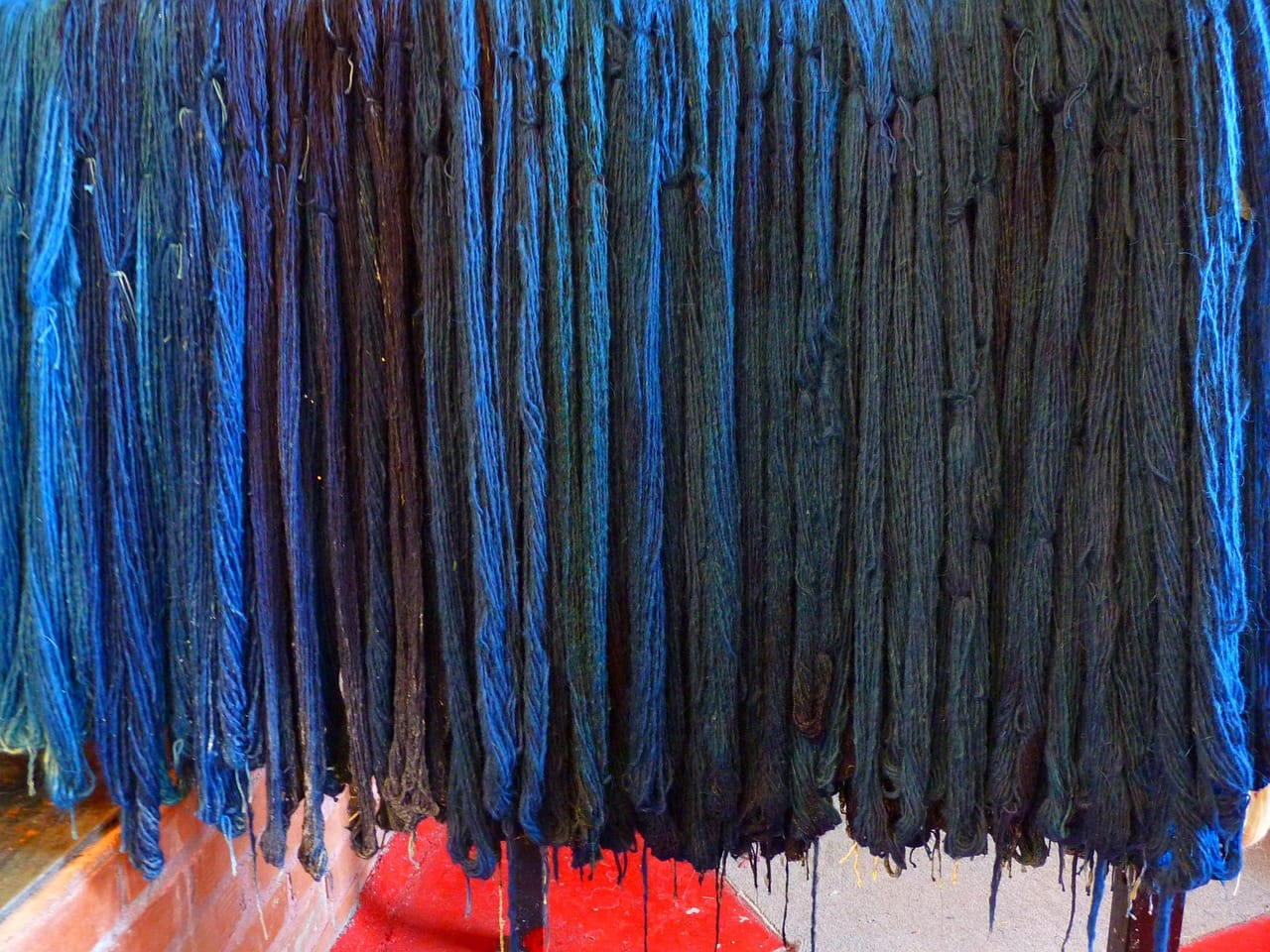 Yarn is dipped in indigo up to thirty times. Between each dip, the air turns it from green to blue.